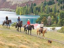 A group of horse riders ride through Walter Peak
