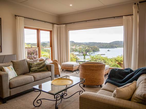 Interior lounge of the Stewart Island Lodge with a view of the ocean from the window