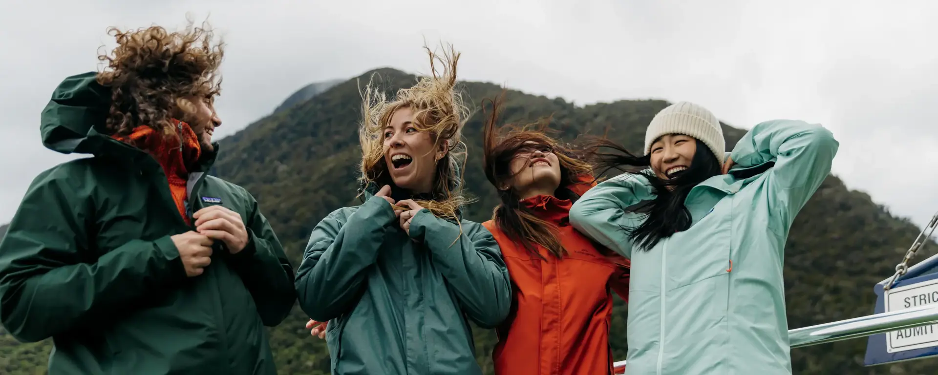 Group of friends laughing together on a Milford Sound cruise.