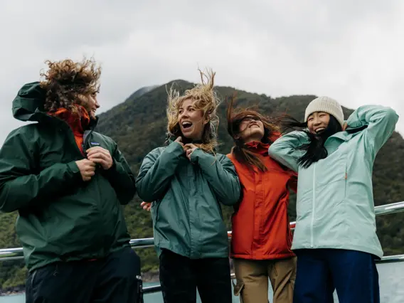 Group of friends laughing together on a Milford Sound cruise.