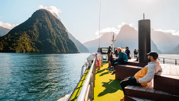 Passengers relaxing on the outdoor deck of a Milford Sound cruise.