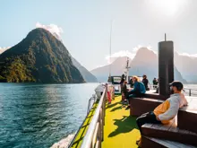 Passengers relaxing on the outdoor deck of a Milford Sound cruise.