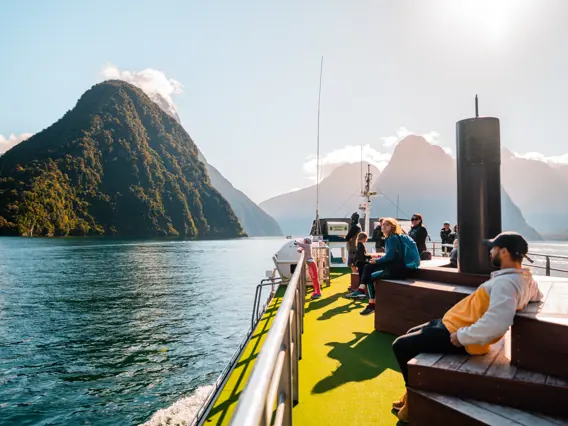 Passengers relaxing on the outdoor deck of a Milford Sound cruise.