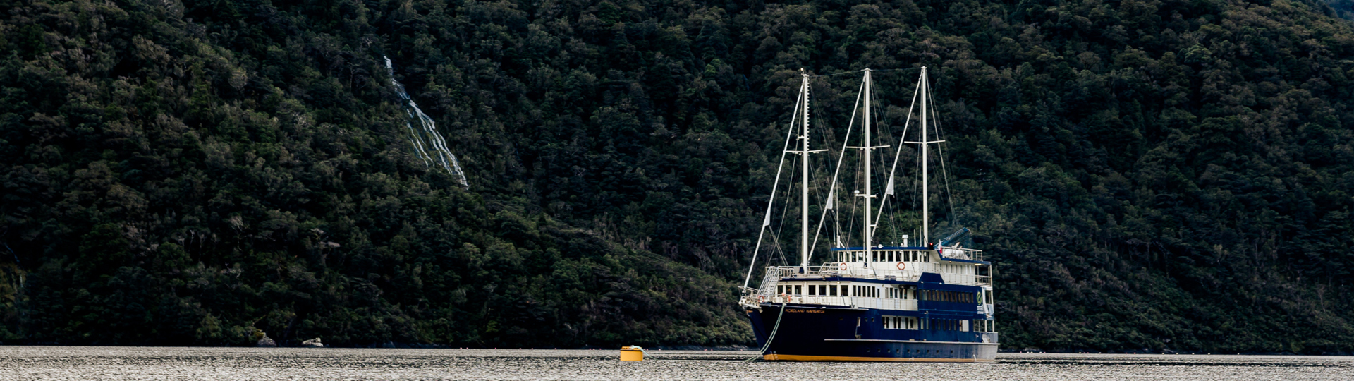 A traditional overnight cruise vessel anchored in an arm of Doubtuful Sound,