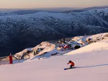 Skier descending a snowy slope at Cardrona Alpine Resort.