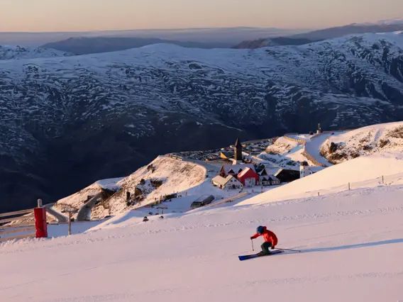 Skier descending a snowy slope at Cardrona Alpine Resort.
