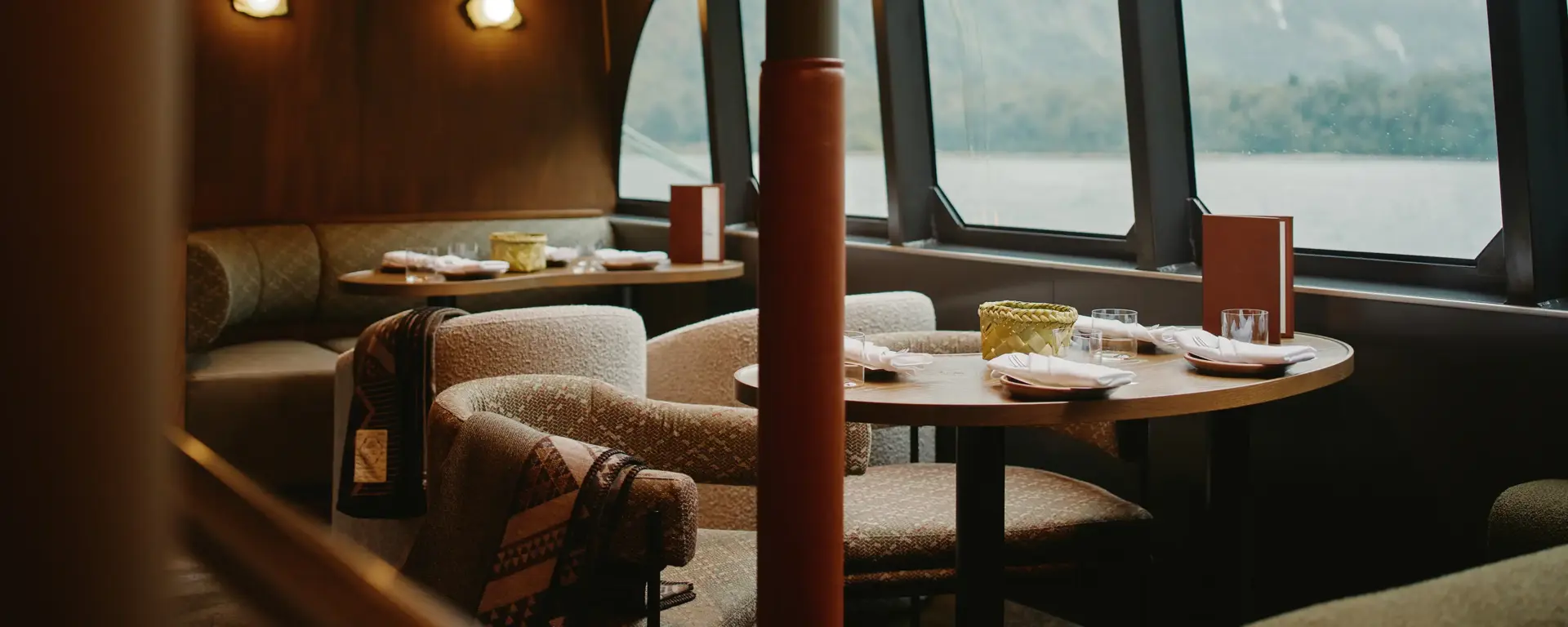 Dining area with large windows aboard a Milford Sound cruise vessel.