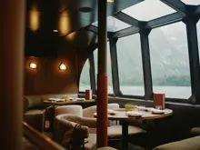 Dining area with large windows aboard a Milford Sound cruise vessel.