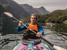 Man kayaking through Doubtful Sound with group