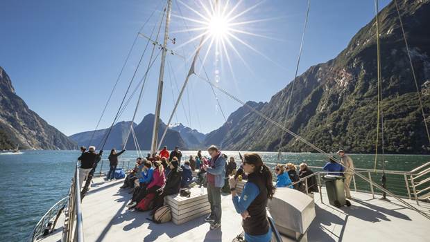 Nature guide speaking to group of tourists on board Milford Sound Cruise