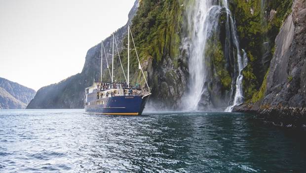 Milford Mariner cruises past waterfall in Milford Sound