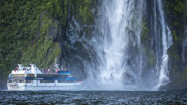 Boat approaching waterfall in Milford Sound