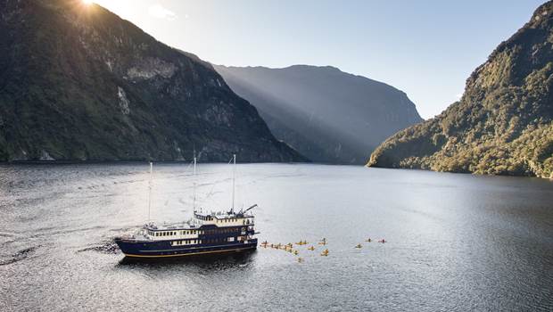 Aerial shot of kayakers exploring Doubtful Sound during the Fiordland Navigator Overnight Cruise