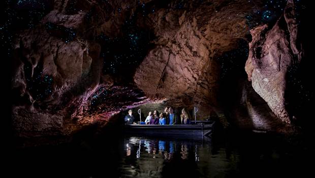 Family and Guide on small boat in the Te Anau Glowworm Caves