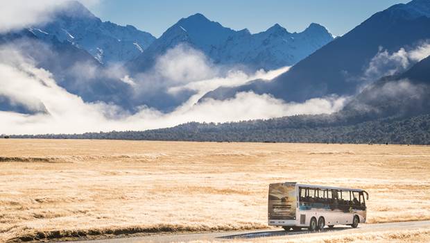 Coach on the Milford Road, snow capped mountains
