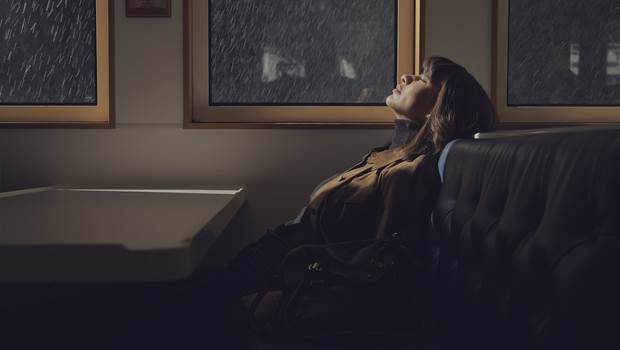 Woman sitting at window enjoying the rain