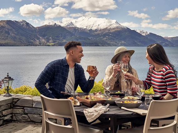 A family dine at Walter Peak with the mountains in the background