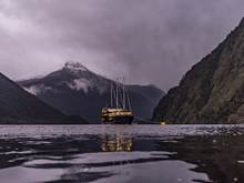 Boat docks of the night in Doubtful Sound with snow-capped mountain