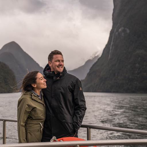 Couple on a boat enjoying the mountain views in Doubtful Sound