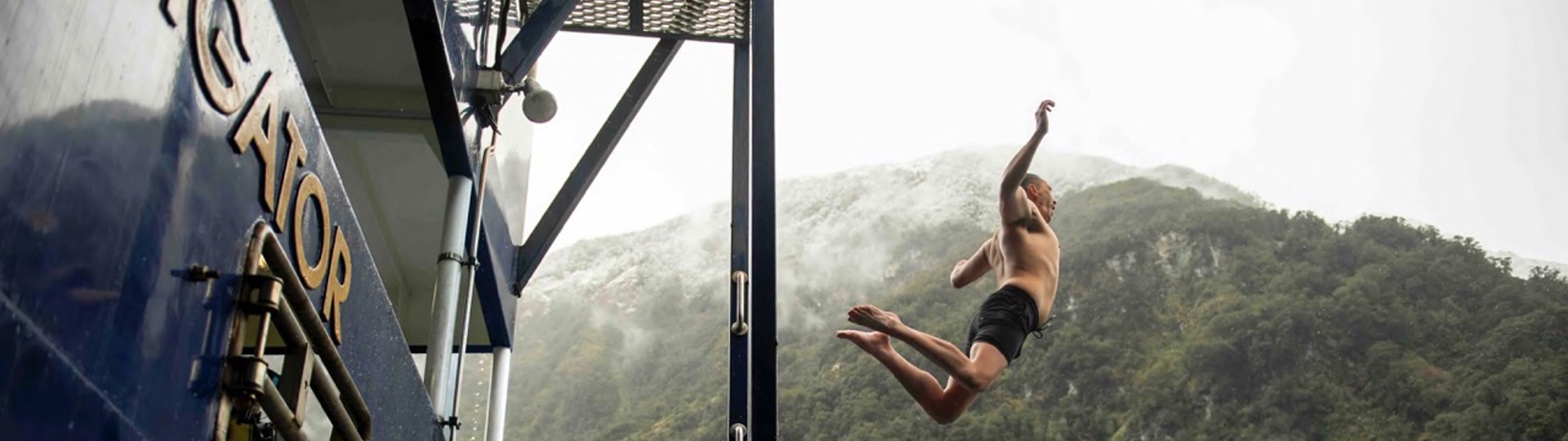 A man jumps off the back deck of the Fiordland Navigator into the water at Doubtful Sound 