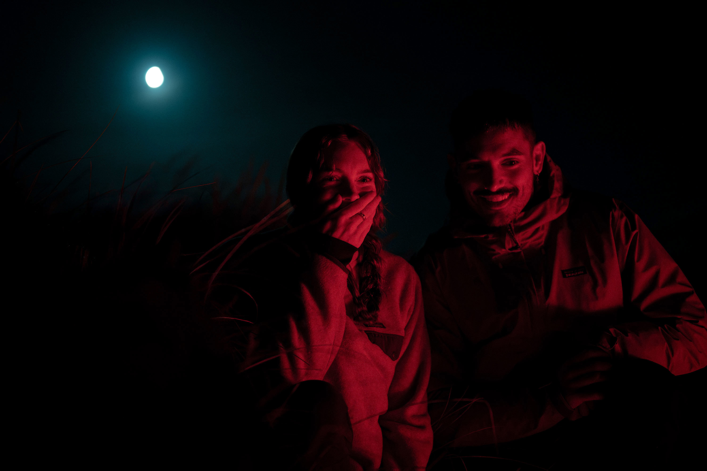 Couple searching for kiwi under a full moon