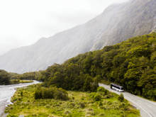 A bus drives past a river on its way back from Milford Sound.