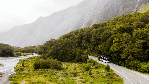 A bus drives past a river on its way back from Milford Sound.