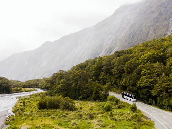 A bus drives past a river on its way back from Milford Sound.