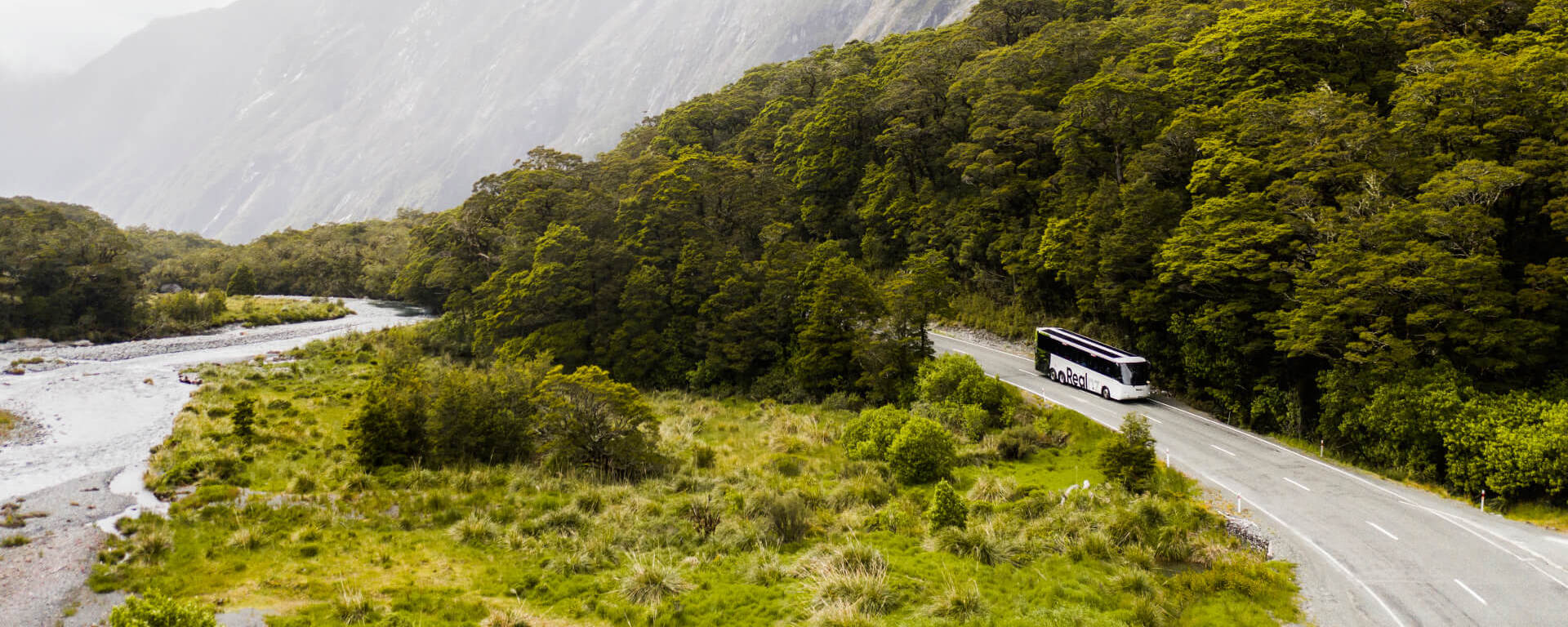 A bus drives past a river on its way back from Milford Sound.