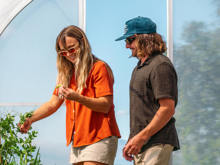 A couple explores Walter Peak’s Garden to Table Experience greenhouse, harvesting fresh vegetables and enjoying a hands-on sustainable experience.