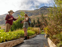 Guests at Walter Peak’s Garden to Table Experience select native trees to plant, surrounded by lush gardens and breathtaking mountain scenery.