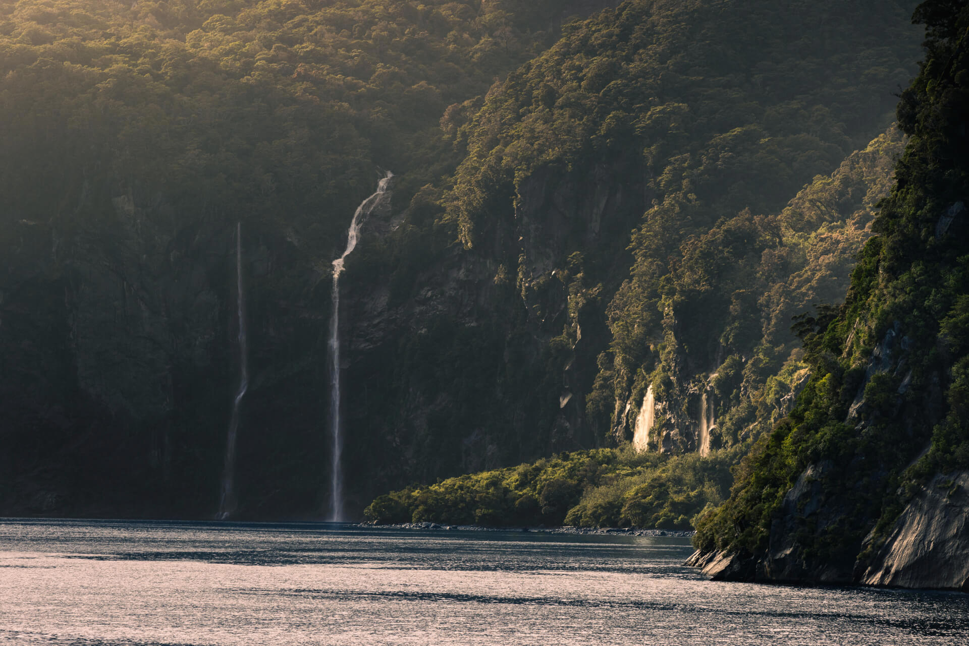 A panoramic photo of Milford Sound with waterfalls cascading into the fiord.