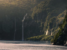 A panoramic photo of Milford Sound with waterfalls cascading into the fiord.