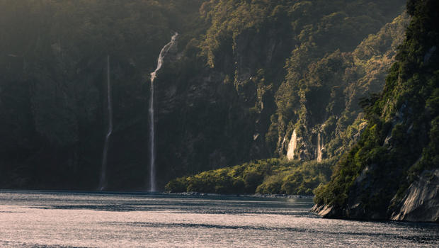 A panoramic photo of Milford Sound with waterfalls cascading into the fiord.