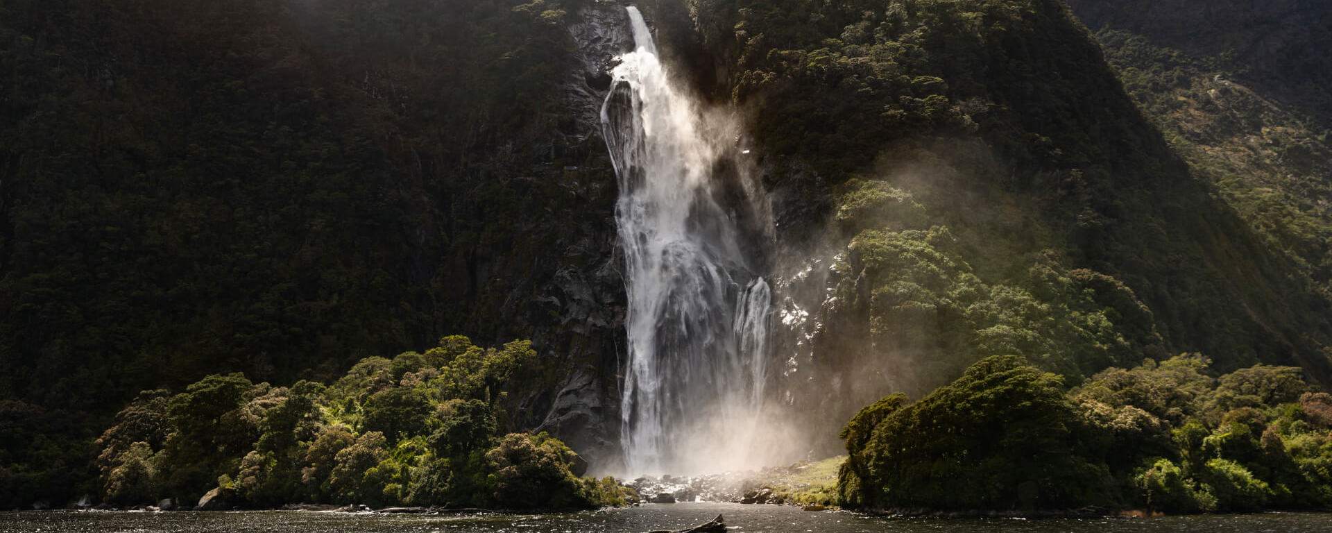 The mighty Bowen Falls thunders down a cliff face and into the ocean beneath.