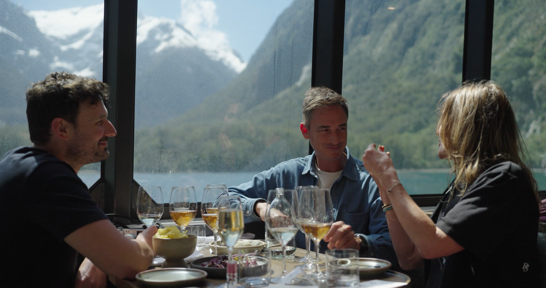 A group of friends enjoying a meal on a premium boat in Milford Sound.