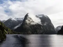 Misty mountains rising above the calm waters of Doubtful Sound.