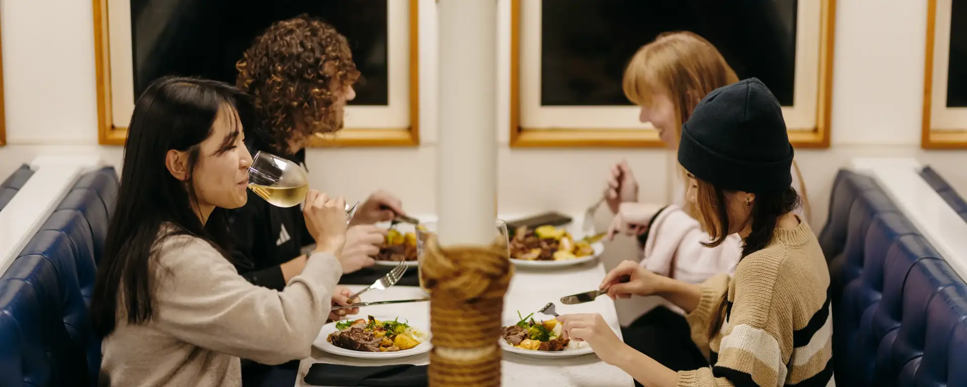 Guests sharing a meal inside a Milford Sound cruise vessel.