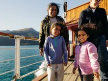 Family enjoying lake and mountain views from a cruise to Walter Peak.