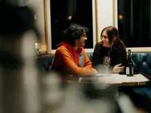 Two guests chatting over a meal aboard an overnight cruise.