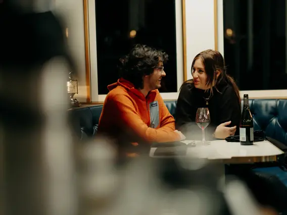 Two guests chatting over a meal aboard an overnight cruise.