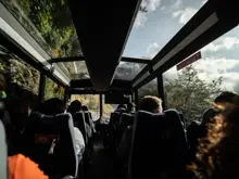 Passengers taking in mountain views from inside a coach.
