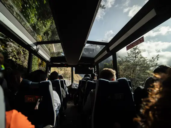 Passengers taking in mountain views from inside a coach.