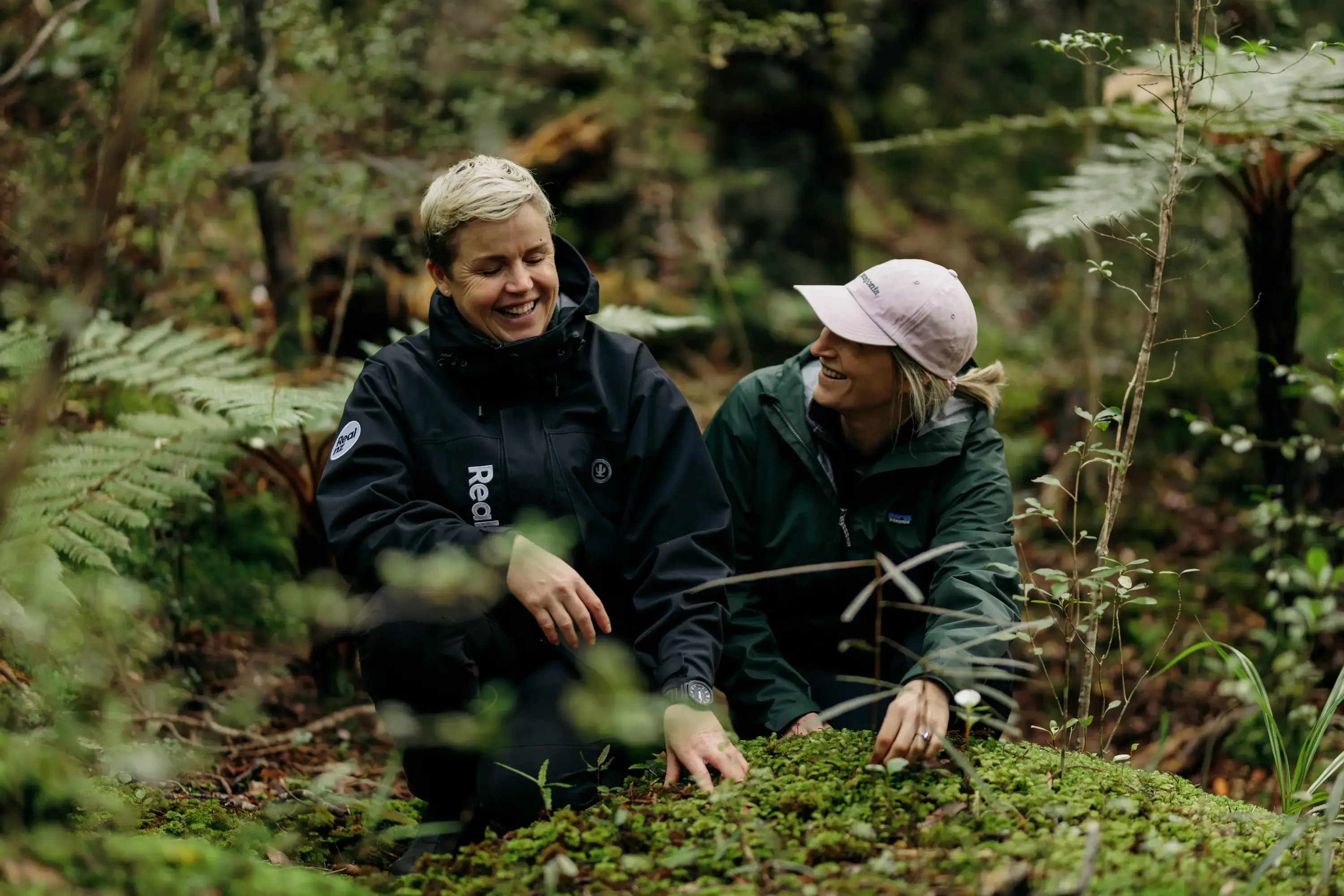 Two people exploring lush native forest on Ulva Island.