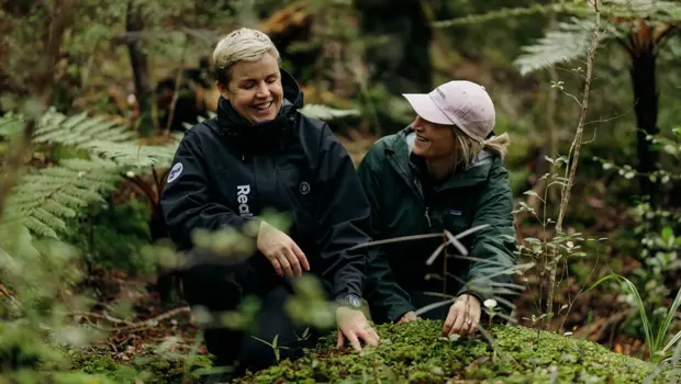 Two people exploring lush native forest on Ulva Island.