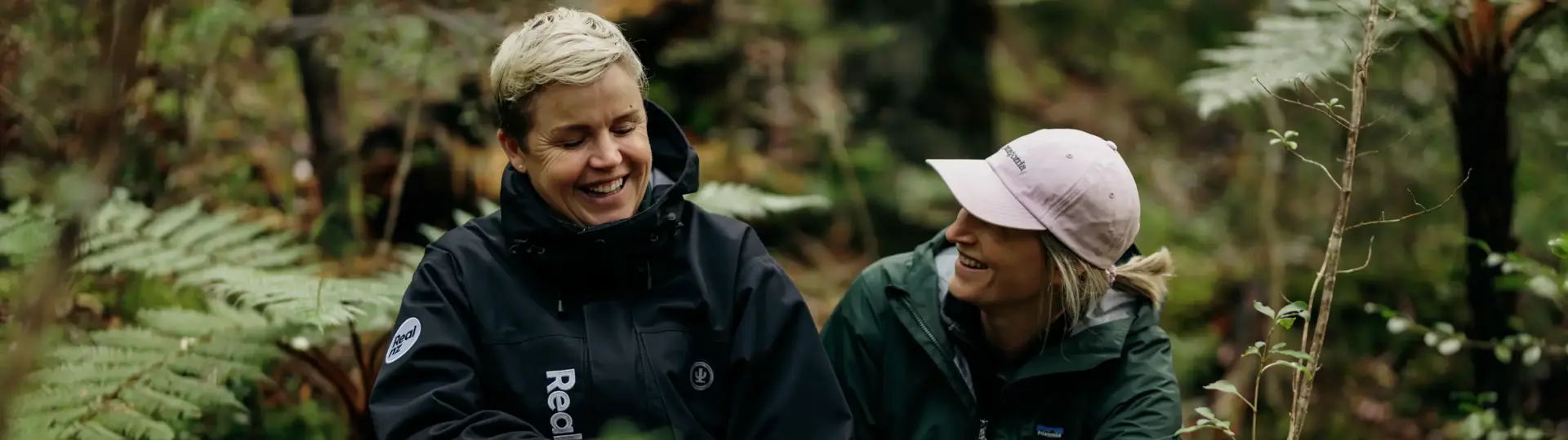 Two people exploring lush native forest on Ulva Island.