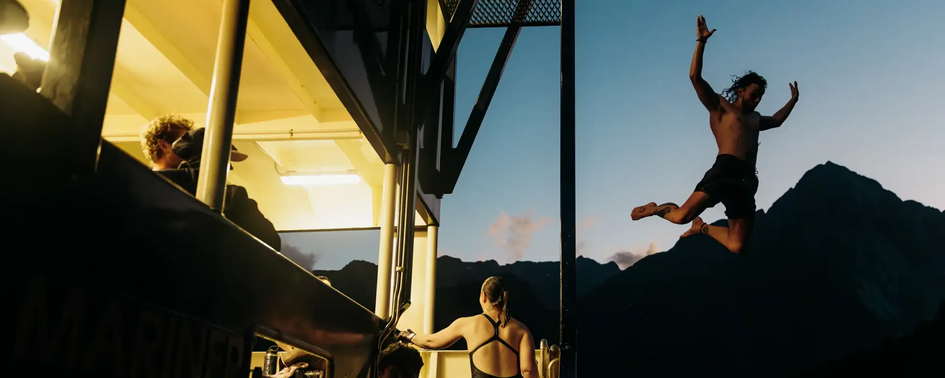 Guest jumping from a cruise vessel at sunset.