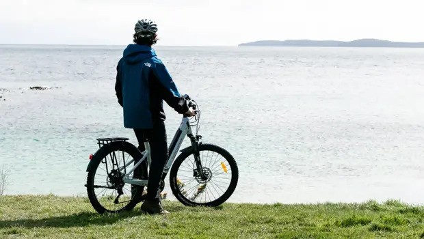 Guest with an e-bike enjoying coastal views on Stewart Island.