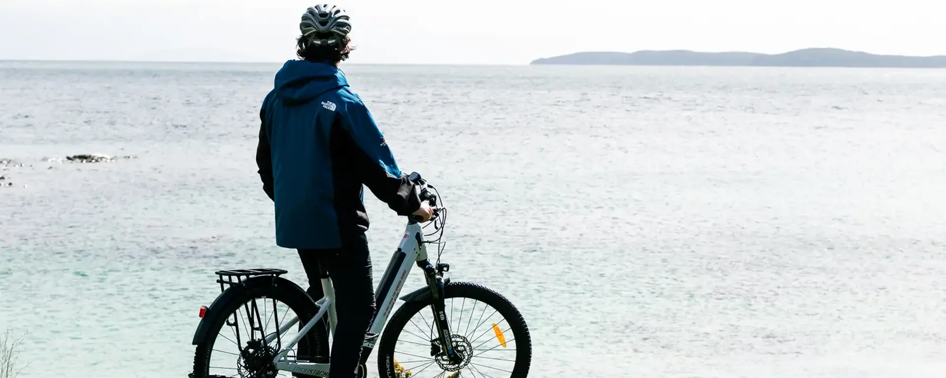 Guest with an e-bike enjoying coastal views on Stewart Island.