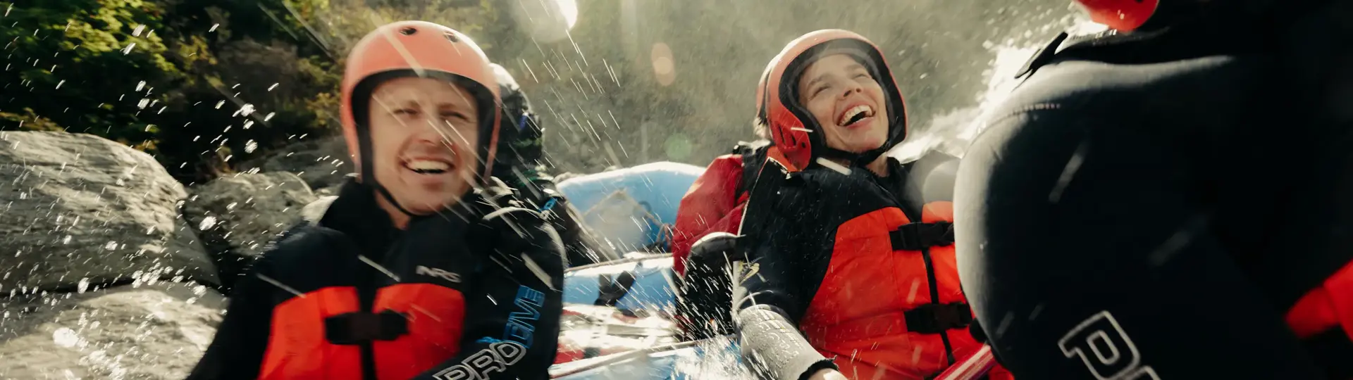 Rafters laughing as they navigate splashing white-water rapids.